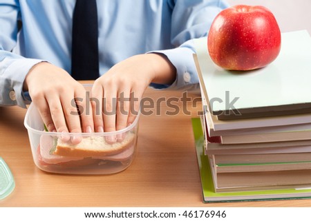 Schoolboy having a sandwich and an apple during his lunch break