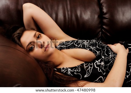 stock photo Beautiful sensual woman sitting on leather sofa