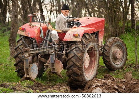 Senior farmer using an old tractor to plow his land