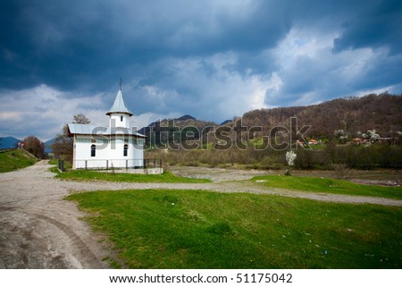 Landscape with a vintage shrine and hills under moody sky