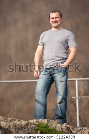 Full length portrait of a young caucasian man outdoors