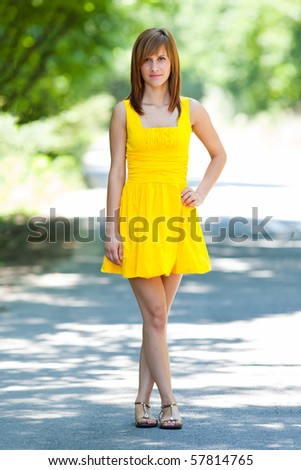 Beautiful blonde woman in yellow dress on the road