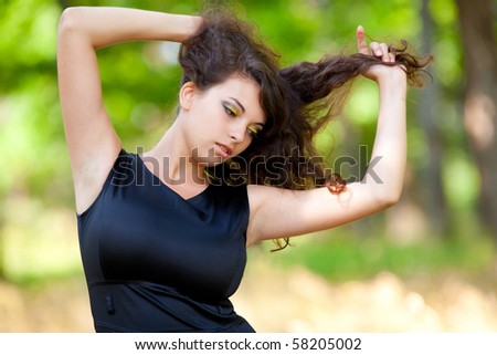 Portrait of a beautiful young woman with black dress in the forest