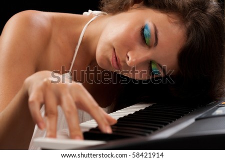 Close up of a beautiful young woman playing piano