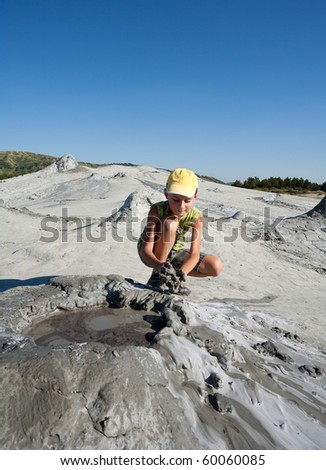 Cute kid playing with mud from muddy volcanoes at Berca, Romania