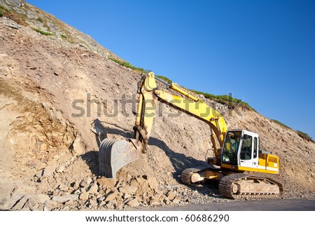 Bulldozer or excavator, industrial machinery against the blue sky