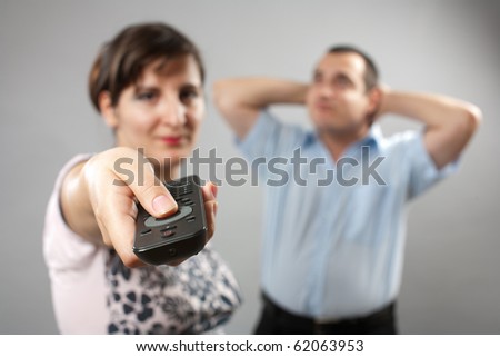 Bored couple, woman using remote control to change the tv channels