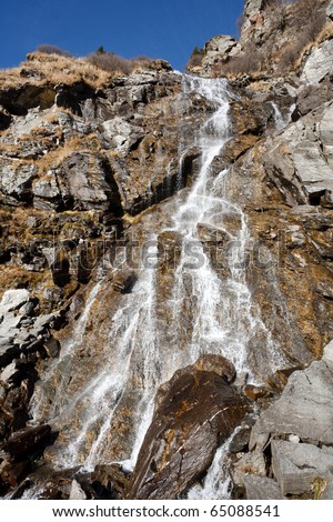 Landscape with a waterfall flowing through rocks in Romanian mountains