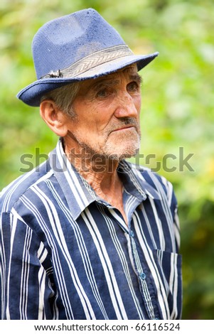 Closeup portrait of a tired old rural man outdoors