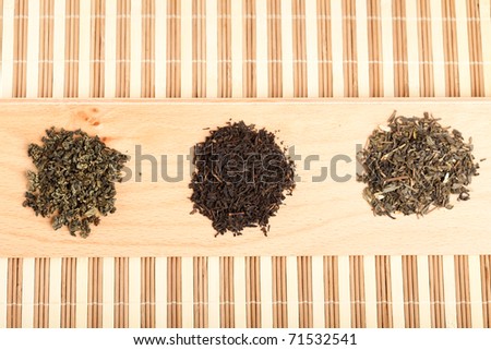 Closeup of three piles with dried leaves tea, of type: jiaogulan, black and green