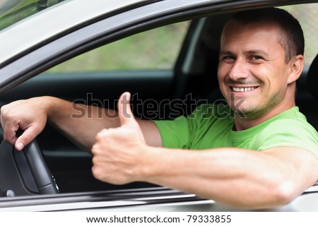 Happy young caucasian man at the wheel of his new car