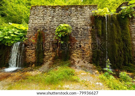 Landscape with an ancient stone wall and water flowing through it