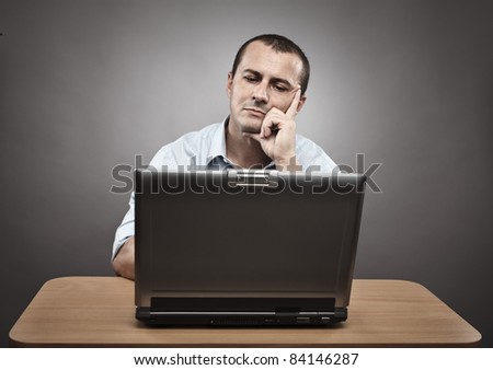 Studio portrait of a thoughtful businessman at his laptop