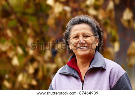 Closeup portrait of a cheerful grandma outdoor in the nature