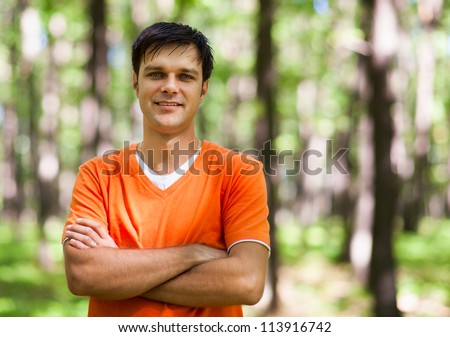 Candid portrait of a young casual dressed man outdoor in a forest