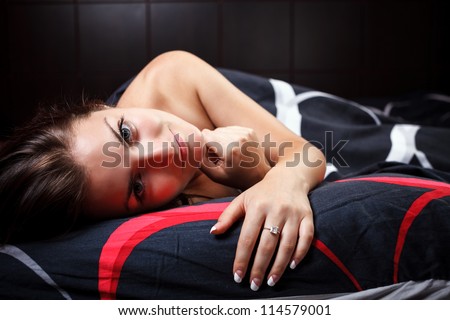 Studio portrait of a gorgeous woman lying in bed with head on pillow