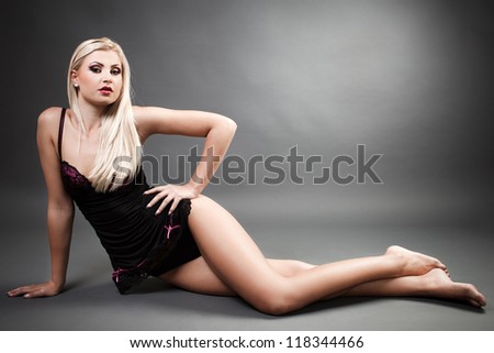 Full length portrait of a beautiful woman wearing lingerie while laying on the floor