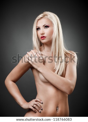 Portrait of a topless blond woman holding hand on shoulder