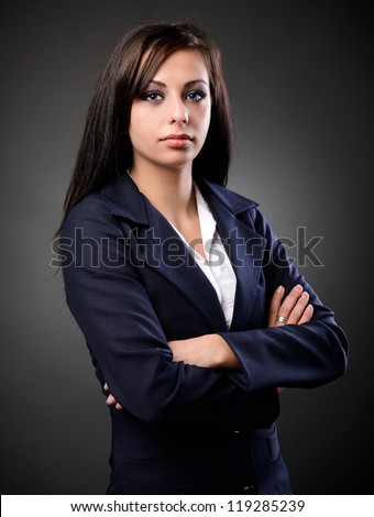 Studio portrait of a latin businesswoman in suit, against dark background