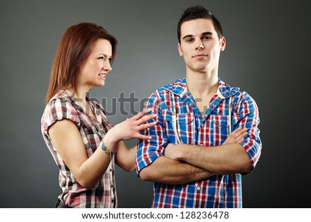 Young woman angry with her indifferent husband. Gray background