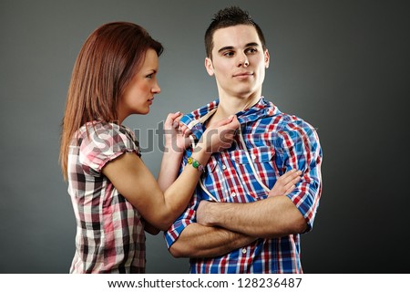 Young woman angry with her indifferent husband. Gray background