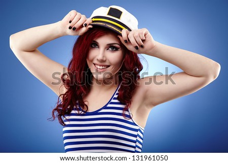 Young woman sailor in glamour closeup pose, over blue background