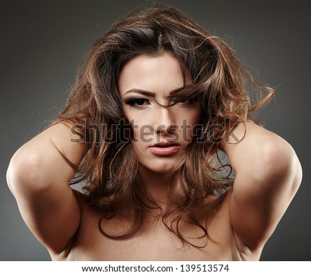 Closeup portrait of a beautiful woman posing with hands in her hair