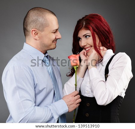 Portrait of a businessman giving a rose to his partner