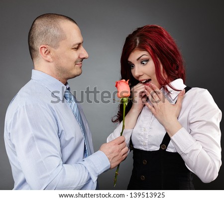 Portrait of a businessman giving a rose to his partner