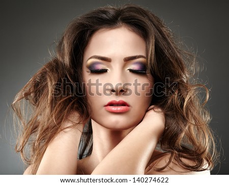 Closeup portrait of a beautiful woman posing with hands in her hair