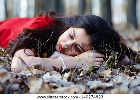 Portrait of a beautiful woman sleeping on the ground in the woods
