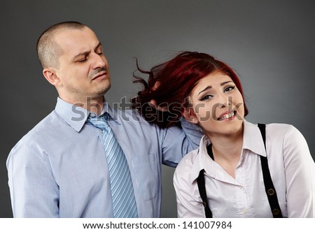Angry boss acting violent on a female employee, while showing an expression of disgust on his face