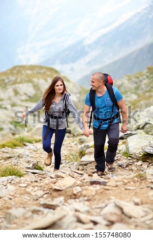 Portrait of a couple holding hands and talking on a mountain trail
