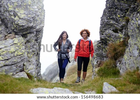 Portrait of friends with backpacks  on a mountain trail