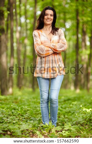 Beautiful woman with arms folded in a forest