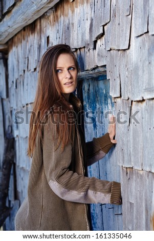 Scared woman being chased and trying to push the door of a cabin log open