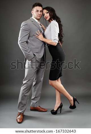 Full length studio portrait of boss and secretary couple  over gray background