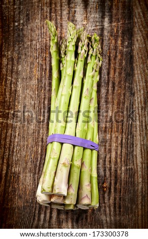 Closeup of a bunch of fresh asparagus on a rustic wooden board