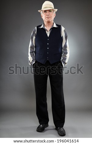 Caucasian senior man of 60 years old standing against gray background