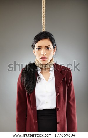 Scared business woman with noose around her neck, about the get hanged