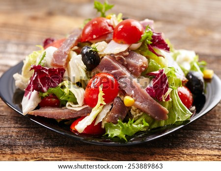 Green and red salad with tuna, cherry and olives, healthy diet food
