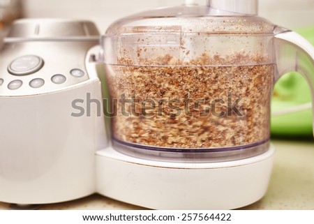 Crushed kernel walnuts in a food processor in motion