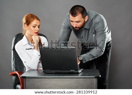 Man helping his business colleague with something on her laptop, collaboration concept