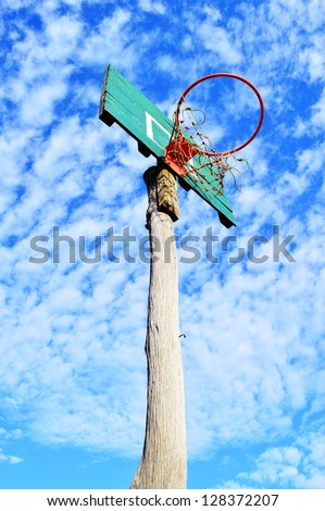 Grunge wooden basket hoop isolated on a blue sky background.