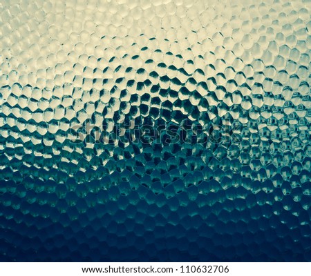 This abstract art image of  bubble glass gives the think of what is that dark area behind it.