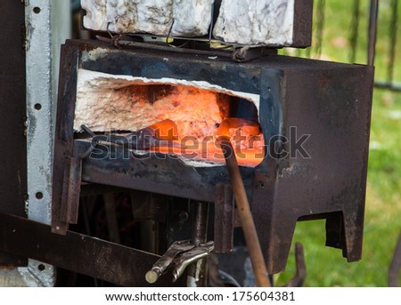 Small black smith oven with iron work heating up in it.