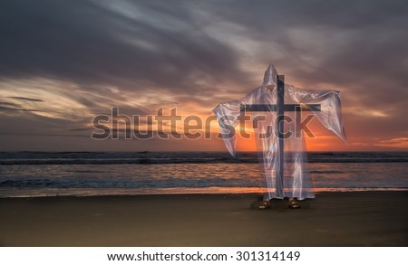 Transparent image of Jesus Christ with a cross on a beach at sunset.