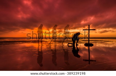 Man walking to a cross and kneeling before it.