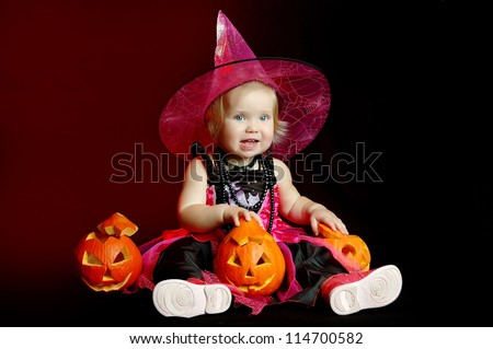 little girl in the witch costume with halloween pumpkin