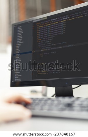 web site source codes on computer monitor. Developer working on source codes on computer at office.